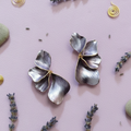 A pair of Purple half floral-shaped metal flower earrings