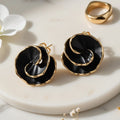 A pair of artisanal matte black and gold-plated sculpted rose stud earrings