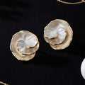 A pair of large, multi-layered gold floral stud earrings with iridescent pearlescent centers