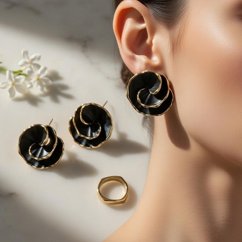 A pair of modern black and gold abstract floral stud earrings