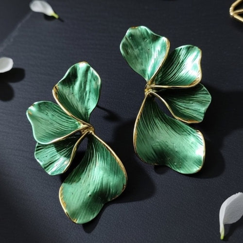 Detailed close-up of textured green ginkgo leaf dangle earrings with gold trim