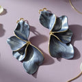 Detailed close-up of textured silver ginkgo leaf dangle earrings