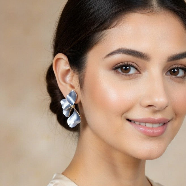 Nature-inspired ginkgo leaf earrings showing gold bezel and silver details.